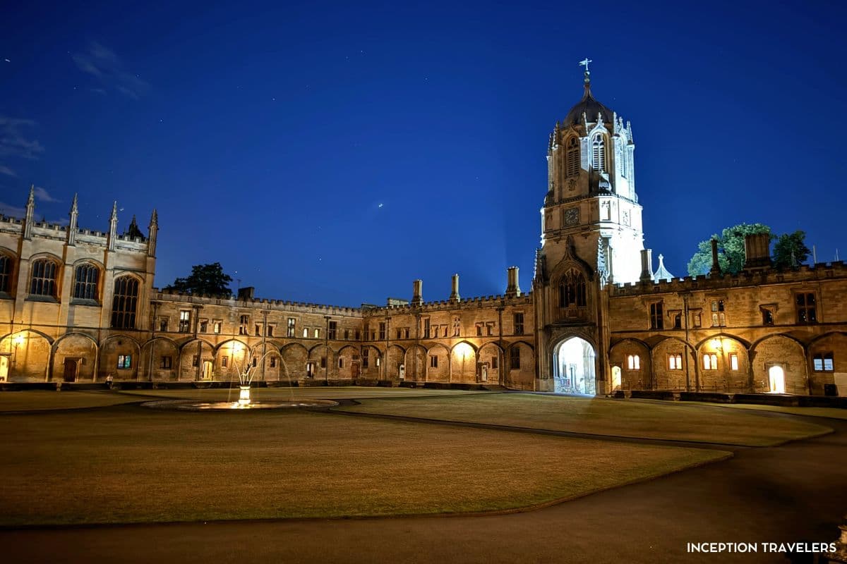 Tom Tower and Christ Church's Tom Quad at night, the central fountain glowing under a deep blue sky