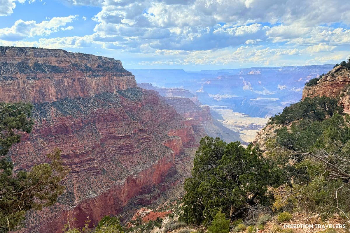 Layered red cliffs of the Grand Canyon stretching from the South Rim to a hazy horizon